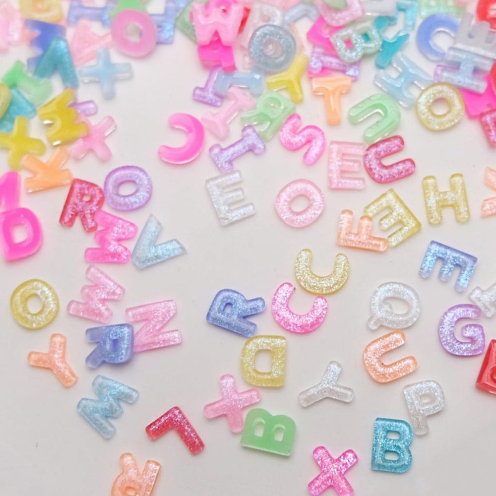 Quezadyl tweezers placing a resin letter showing precise application and professional finish benefit