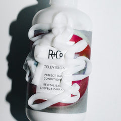 R+Co Television conditioner held in hand demonstrating 1000 ml jumbo size