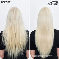 Redken conditioner being applied to wet hair in hand to show easy application and coverage