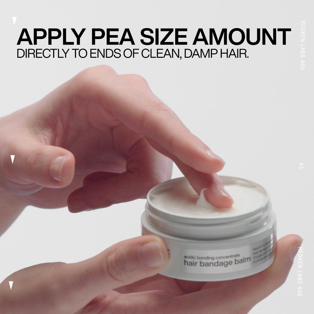 Redken balm dispensed on palm showing recommended small amount