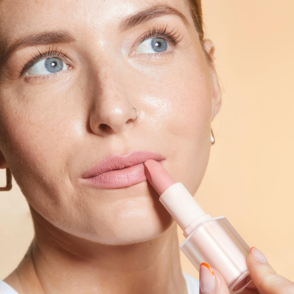 Revolution Lip Allure next to a coin showing 0.11 oz size and convenient portability