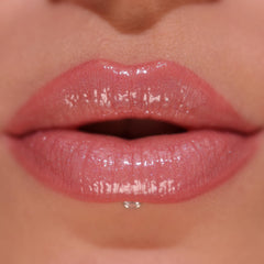 Revolution Pout Bomb texture swipe on lips showing shimmer and hydrating finish benefit