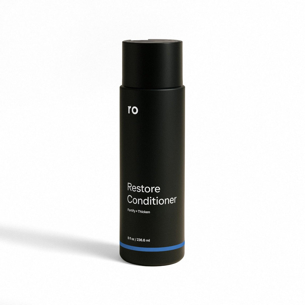 Ro bottle front view showing product and benefit of fuller-looking hair