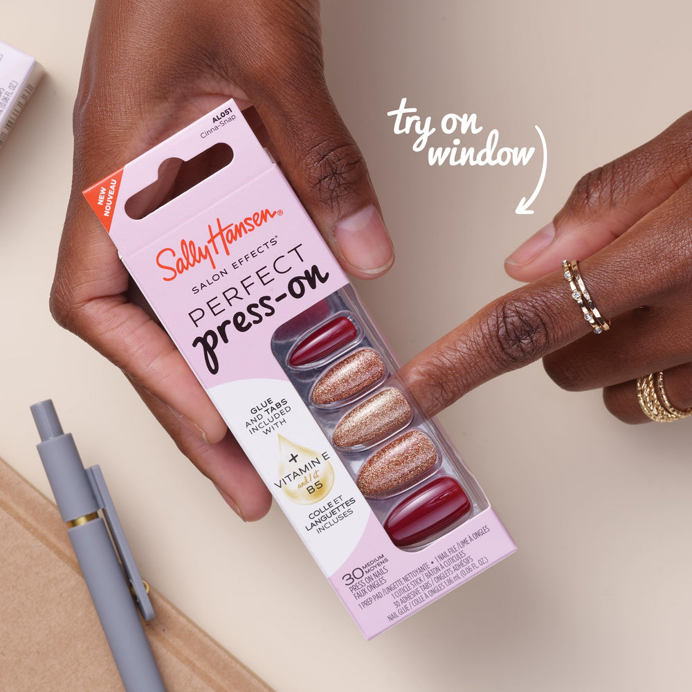 Hand applying a Sally Hansen press-on nail demonstrating easy at-home application