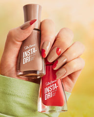 Sally Hansen bottle next to a coin for scale showing compact size and travel convenience