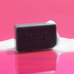 Seaweed Bath Co. bar next to soap dish showing compact 3.75 oz size benefit