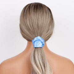 Semato scrunchie beside coins showing scale and portable convenience