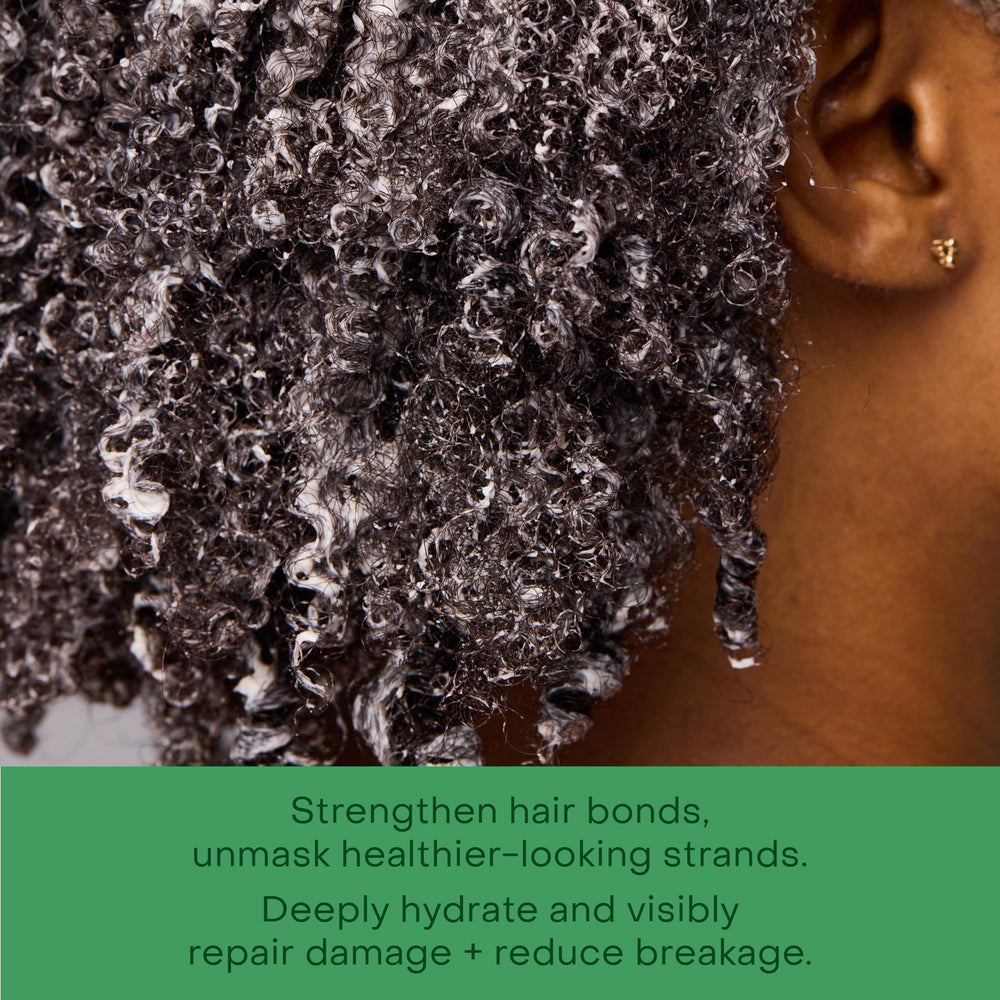 SheaMoisture applying masque to wet hair demonstrating deep conditioning