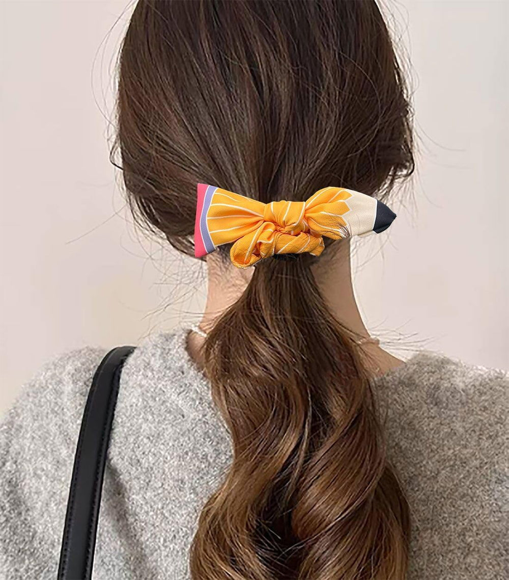 SKIRIFLA hair ties next to a pencil showing size and classroom-themed scale