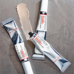 Smashbox primer size comparison next to makeup brush to show compact travel-friendly volume