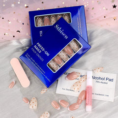 Stbisen application kit laid out with nails, sticky tabs, glue, file, and cuticle stick