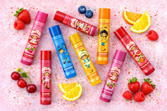 Strawberry Shortcake balms arranged on desk with notebook, convenient everyday hydration