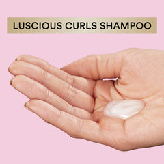 Suave pink luscious curls bottle in hand to show 16.5 oz scale and travel-friendly size
