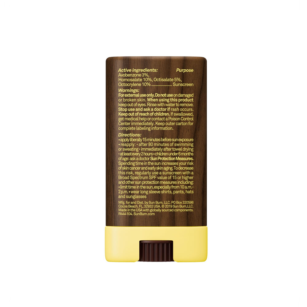 Sun Bum face stick on a beach towel illustrating water-resistant outdoor use