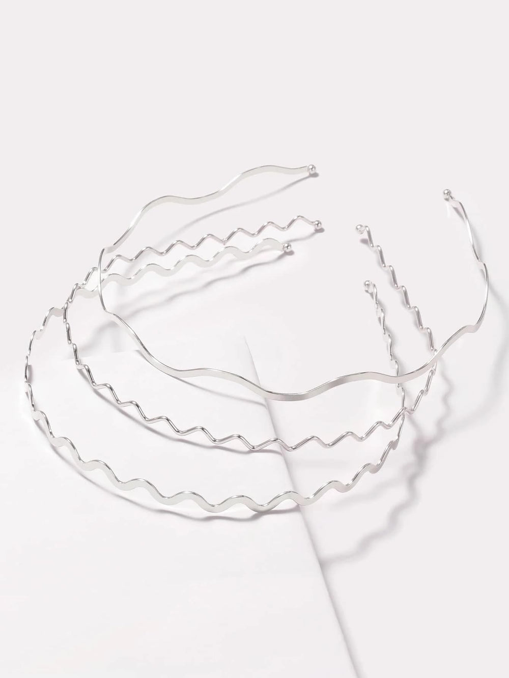 TEBIEKOY front view of three silver wavy headbands showing polished finish and versatility