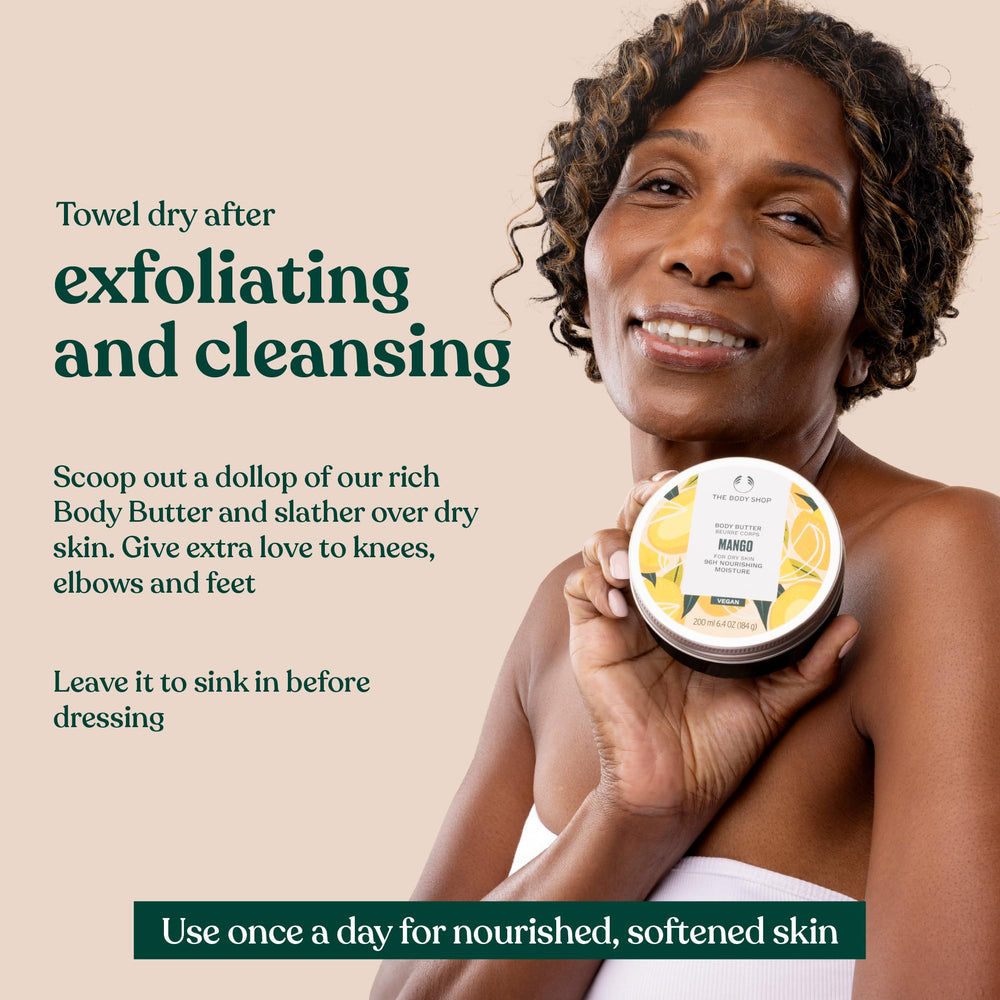 The Body Shop mango body butter next to a passport in a travel pouch showing compact, travel-friendly size