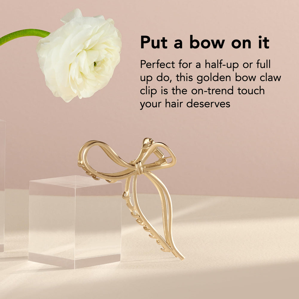 The Hair Edit clip in hand for scale showing compact size and travel convenience