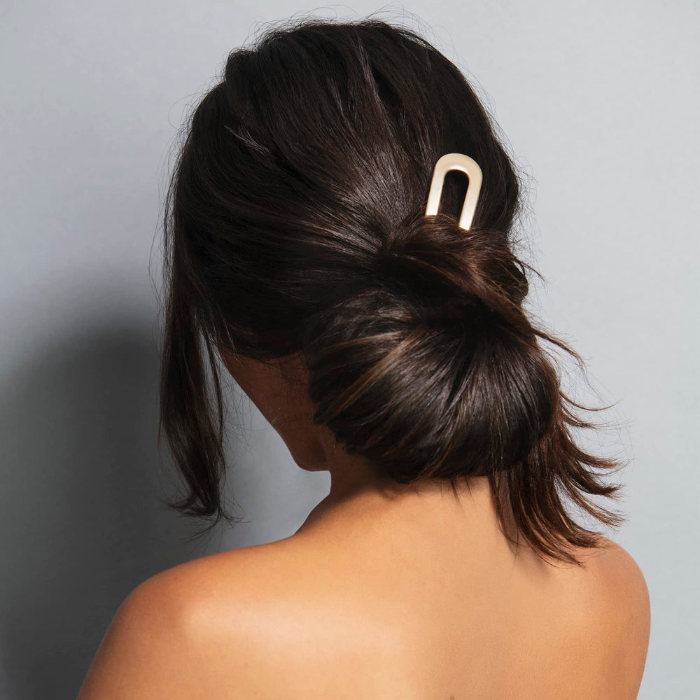 The Hair Edit close-up shows soft gold finish and smooth surface for gentle hold benefit