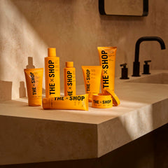 The Shop Uninterrupted bottle next to a razor showing 4 fl oz travel-friendly size
