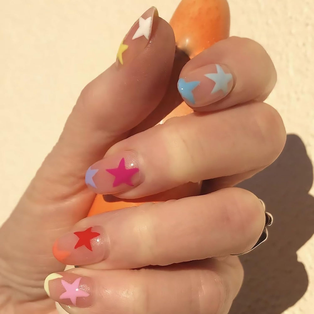 Tyuimhx front package shot showing 24 colorful star press-on nails and included tools, visual convenience