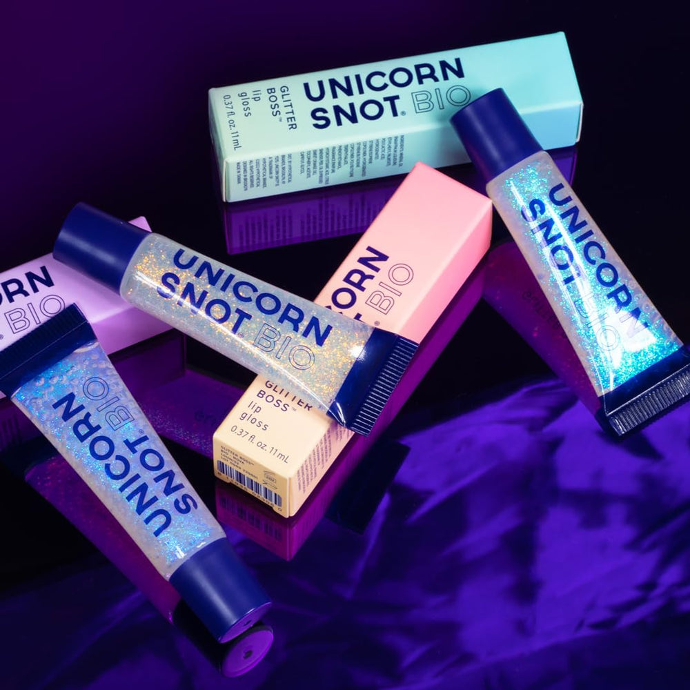 UNICORN SNOT tube next to a phone illustrating compact 0.37 fl oz pocket-ready size