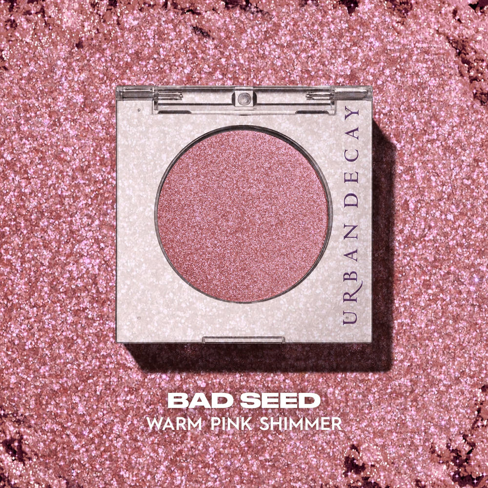 URBAN DECAY swatch of Bad Seed on forearm showing vibrant shimmer payoff