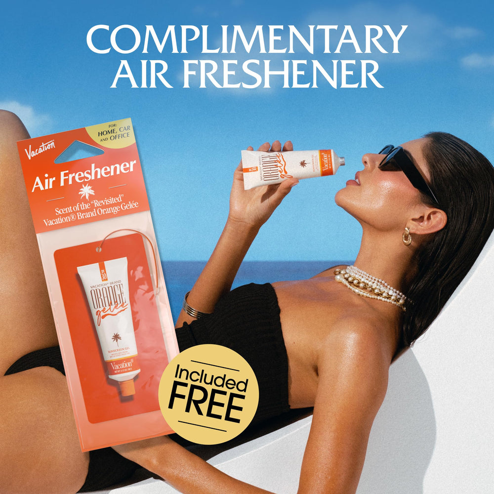 VACATION lifestyle shot applying sunscreen on beach for luminous skin