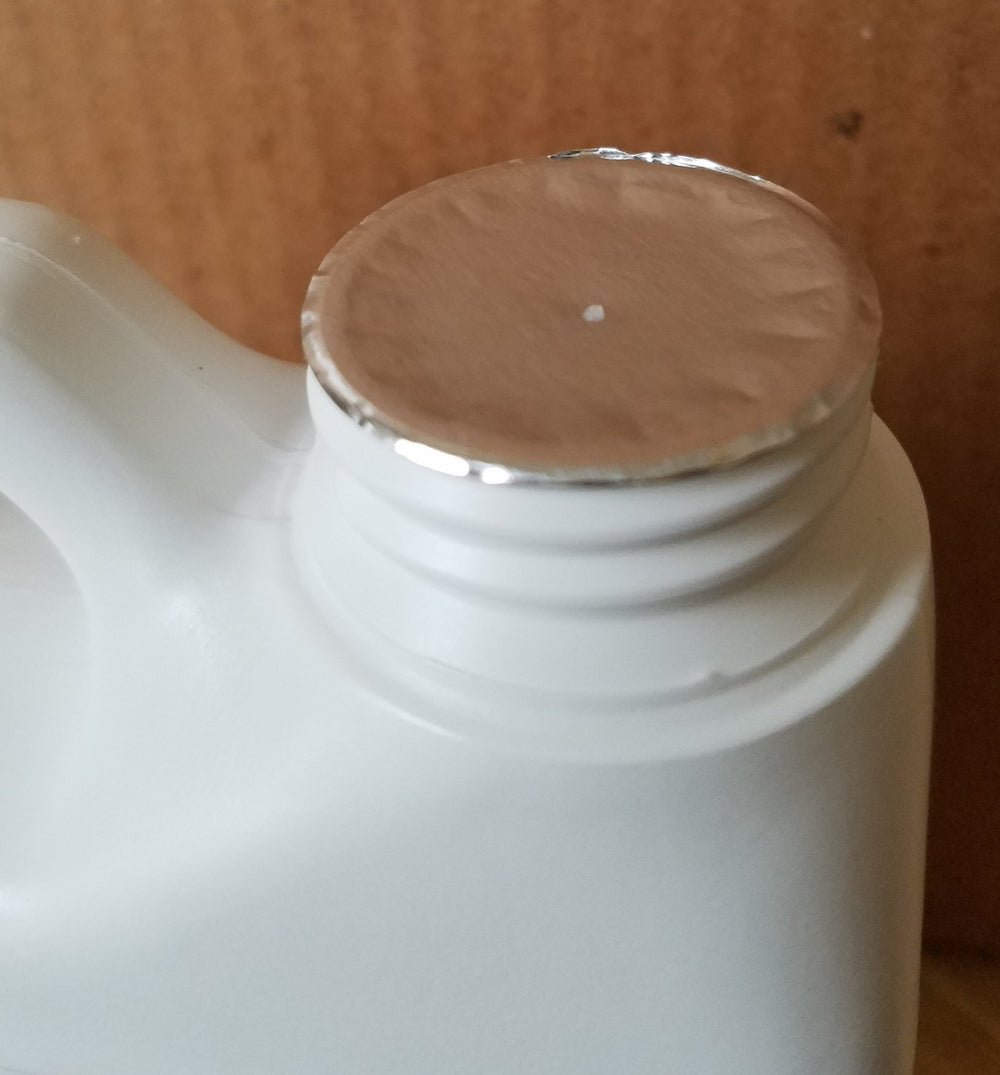 Verdana neem oil gallon jug beside common bottle showing scale benefit