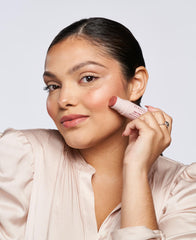 Wander Beauty applying stick to cheek for quick on-the-go hydrating flush