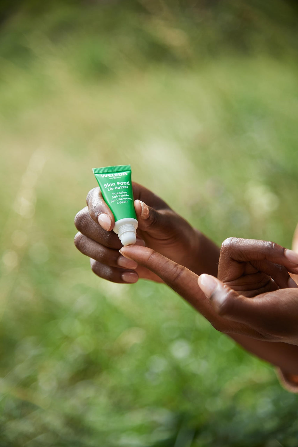 Weleda lip butter ingredients flatlay with sunflower, chamomile, calendula for natural care