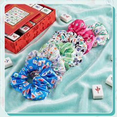 Yuxung scrunchie beside a hand to show scale and versatile fit for most hair types