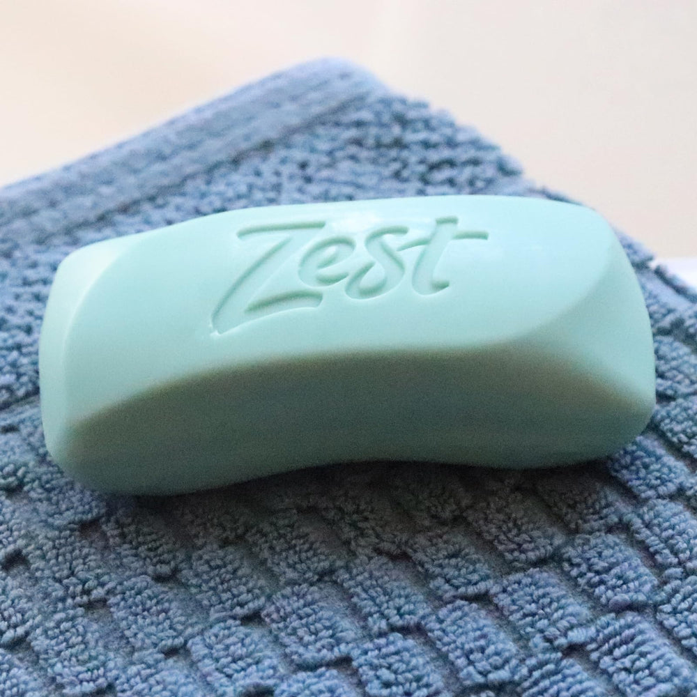 Zest bar size next to hand illustrating compact travel-friendly benefit