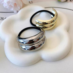 ZEYER metal hair cuff next to coin for scale, compact and travel-friendly convenience