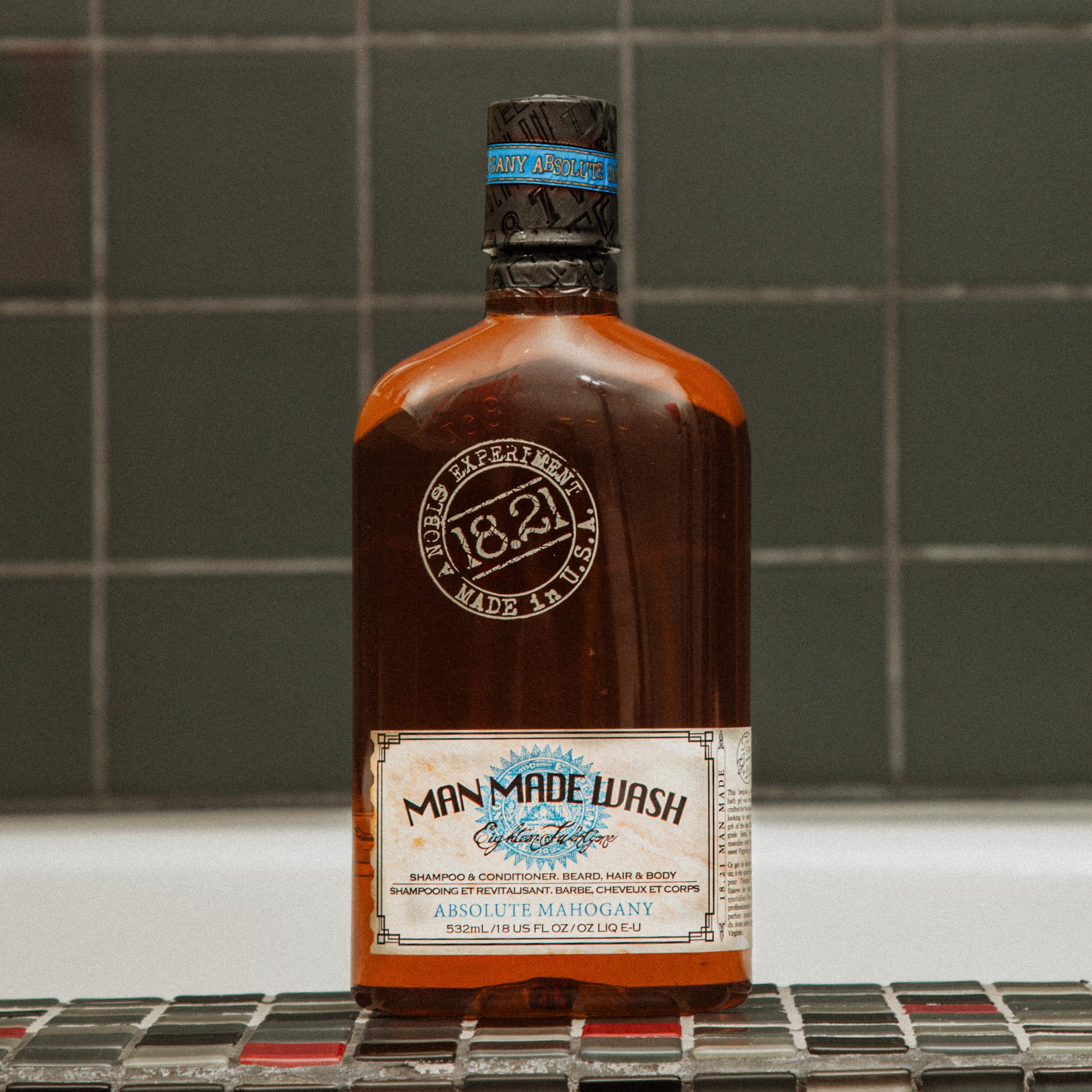 18.21 Man Made bottle in hand to show 18oz scale and travel-friendly convenience