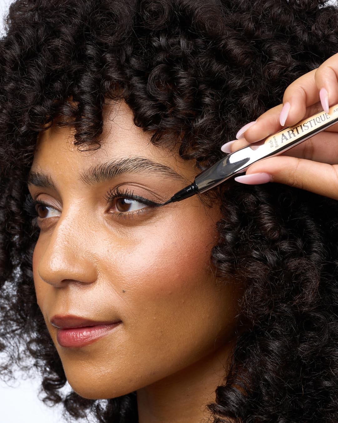 Absolute New York eyeliner in hand applying a sharp wing for controlled, smudge-free results