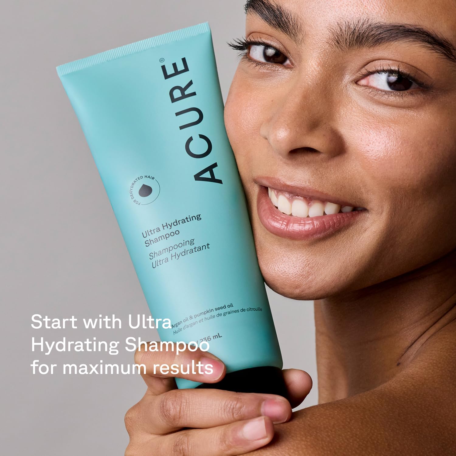 Acure conditioner next to hand showing 8 fl oz size and travel-friendly benefit