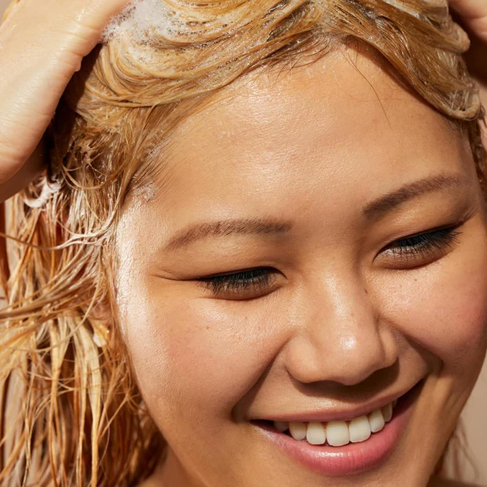Acure shampoo in shower being applied, demonstrating easy lathering