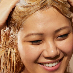 Acure shampoo in shower being applied, demonstrating easy lathering