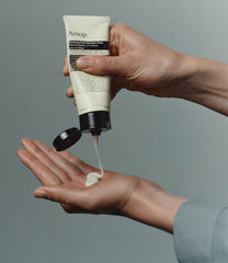 Hand applying Aesop paste showing easy application and spreadability