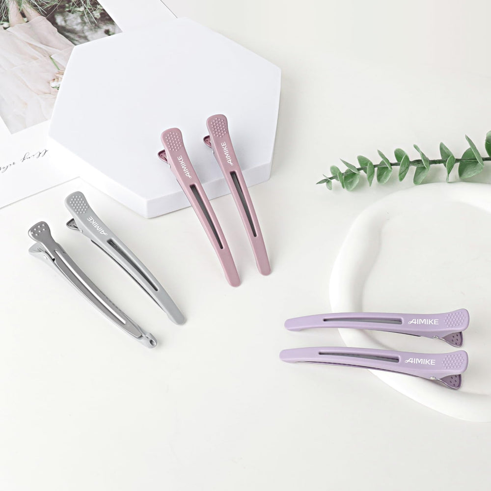 AIMIKE clip held in hand for scale showing compact, salon-ready size