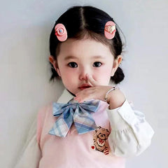 Akutoer clips beside ruler showing 1–2 inch size for children