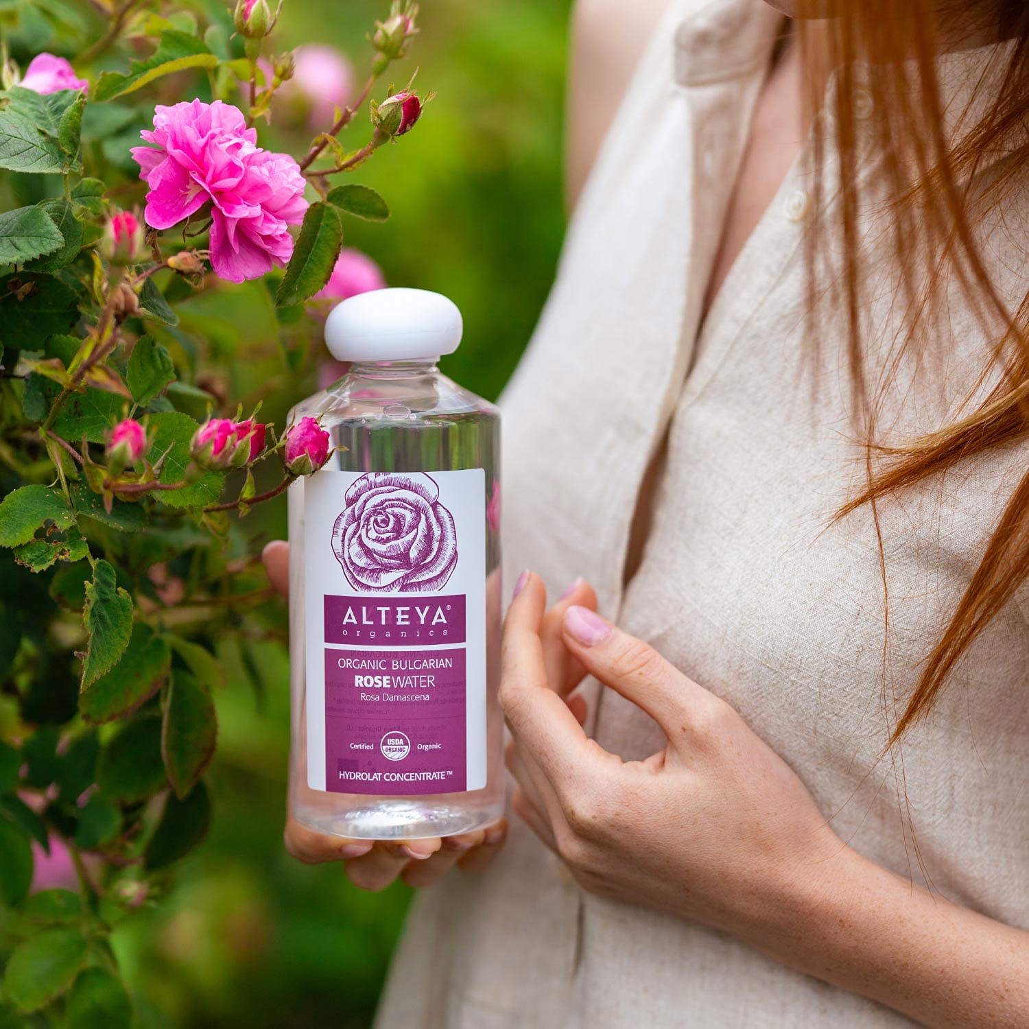 Alteya Organics bottle on bathroom vanity with towel, suggests daily skincare ritual use