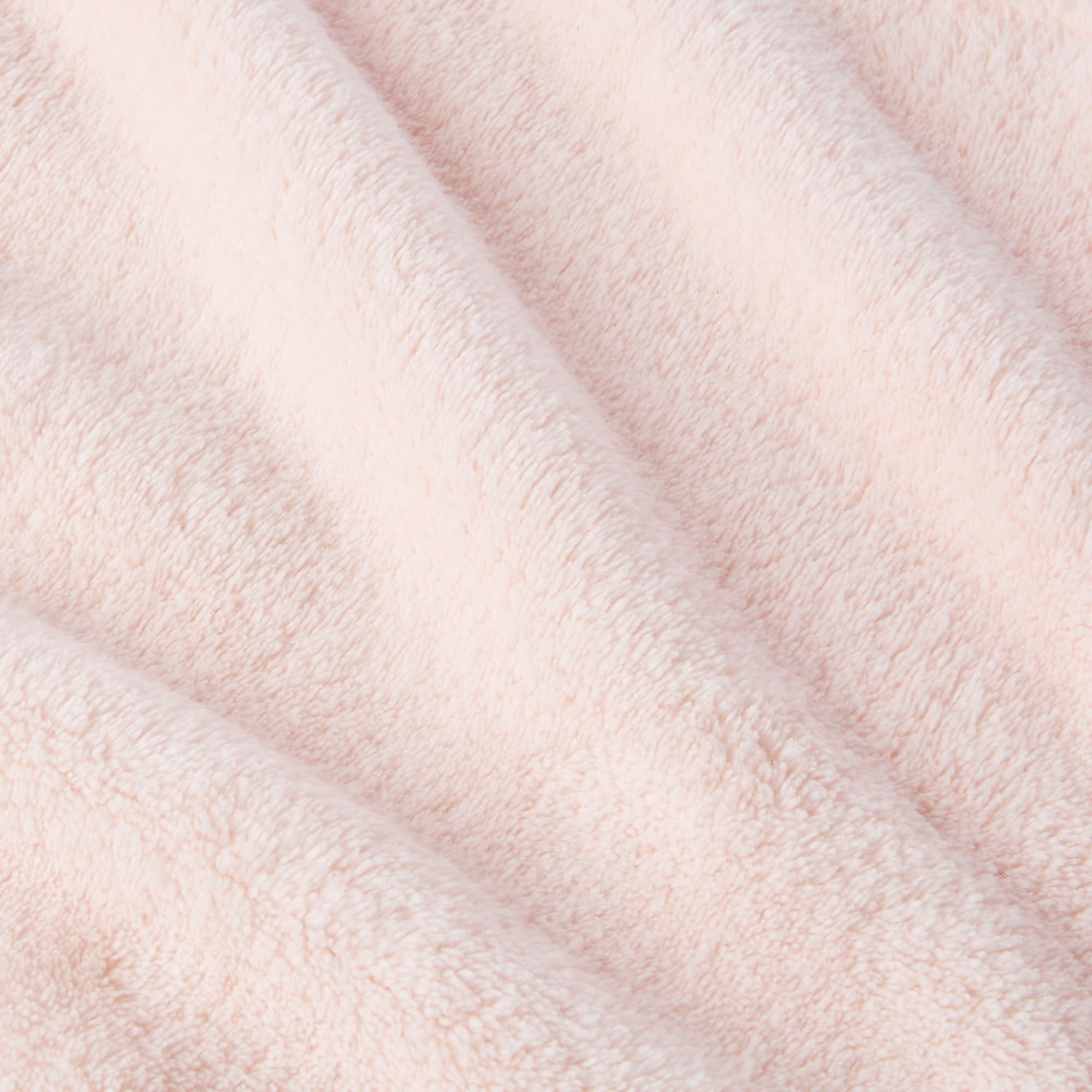 Amazon Basics towel next to hand showing size and lightweight benefit