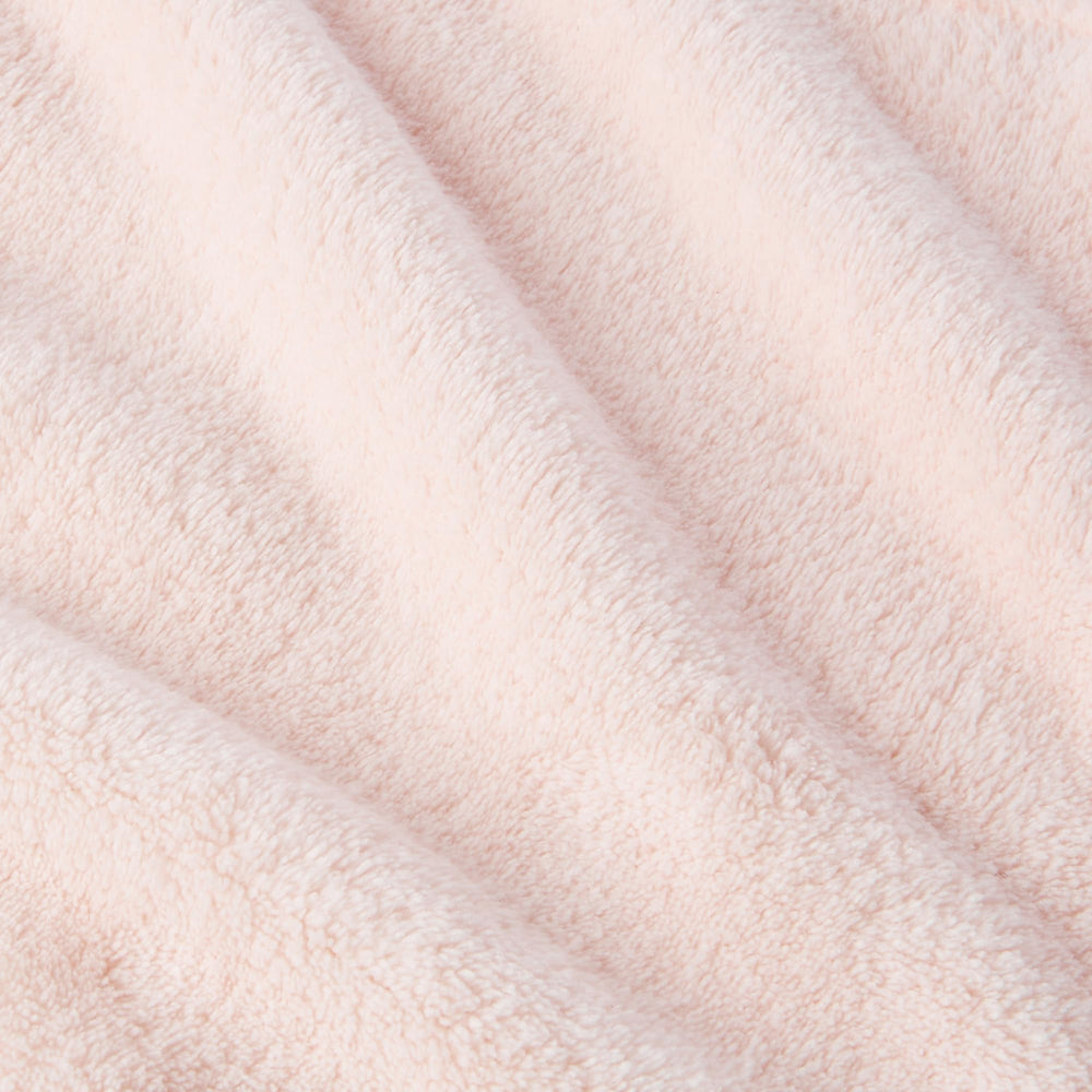 Amazon Basics towel next to hand showing size and lightweight benefit