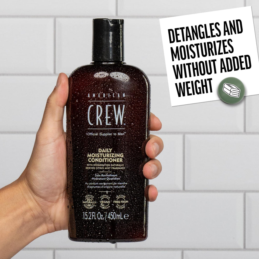 American Crew conditioner being massaged into wet hair in shower for effortless detangling benefit