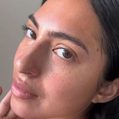 APTO applying oil to face highlighting dewy, glassy finish