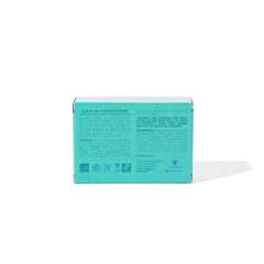 Hand applying As I Am leave-in bar to damp hair to show slip and detangling benefit
