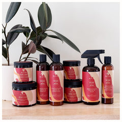 As I Am bottle held in hand to show 12 ounce scale and travel-friendly size advantage