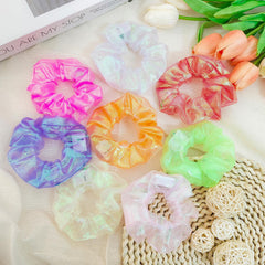 Asawira scrunchie next to hand showing scale and easy carry benefit