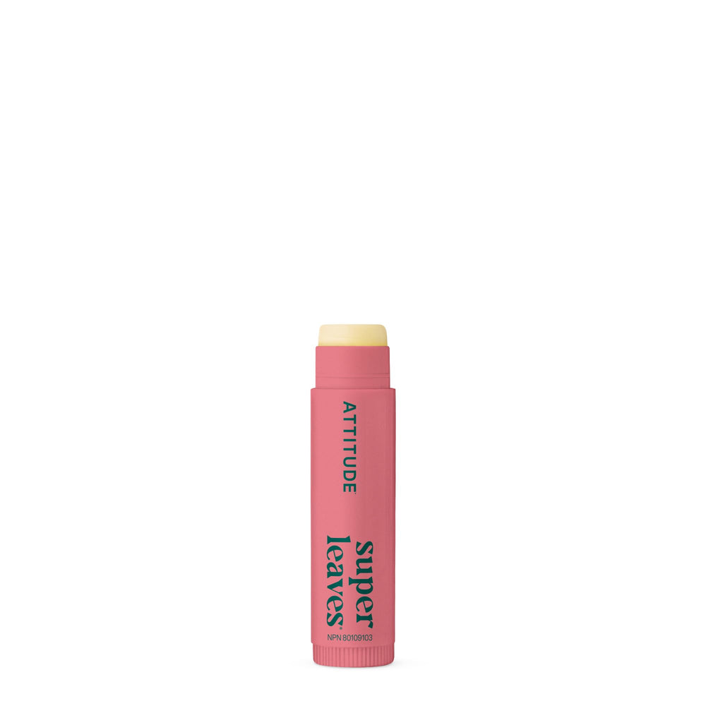 ATTITUDE applying lip balm at the beach showing everyday sun protection benefit